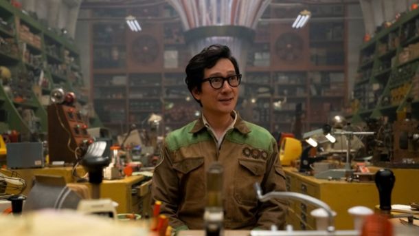 A Imagem mostra um homem de aspecto jovem e com cabelos pretos, usando uniforme de trabalho. O homem parece super ocupado e está com a mesa de trabalho desorganizada.