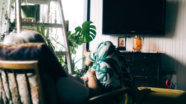 pessoa sentada de costas, vendo tv