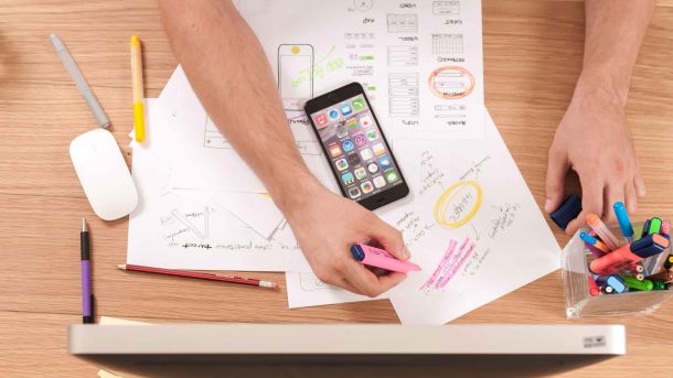 papéis sobre uma mesa, com muitas anotações e destaques sobre as tendências de RH para 2023