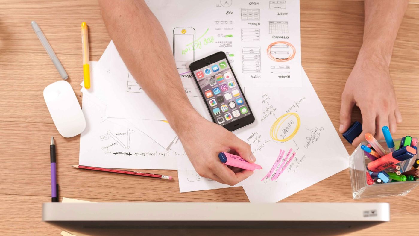 papéis sobre uma mesa, com muitas anotações e destaques sobre as tendências de RH para 2023